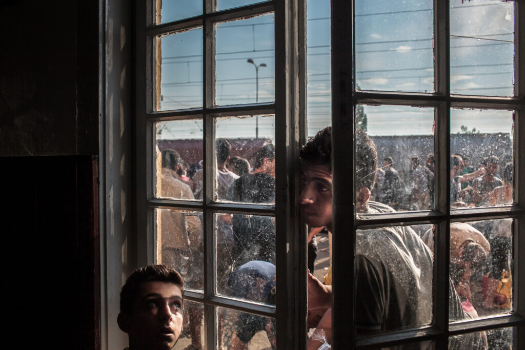 GEVGELIA,MACEDONIA - AUGUST 8, 2015: A young refugee is looking through a window of train station in Gevgelia, Macedonia, while waiting to board the train headed towards Serbia. Each day about 1500 refugees cross from Greece to Macedonian town of Gevgelia with intention to reach any of European Union countries and to receive status of asylum seekers there.