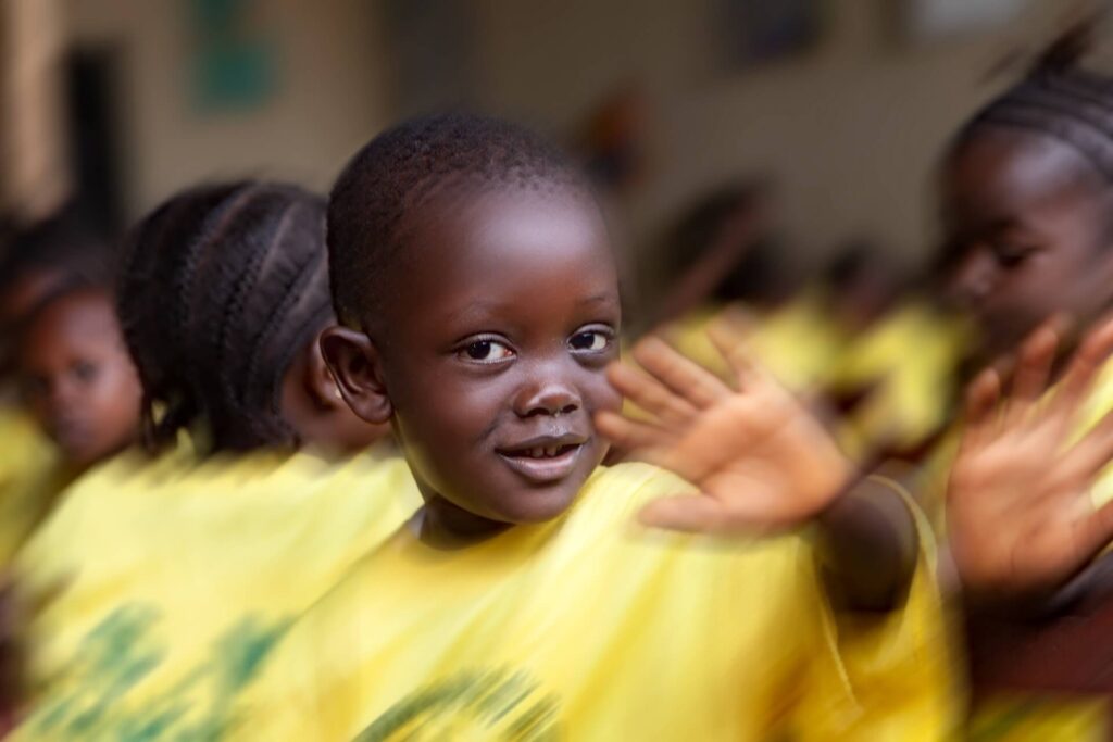 Foto 4 _"Il saluto" chiude il percorso con un gesto che attraversa il tempo: un bambino che saluta, come se riconoscesse chi guarda. È la promessa di una nuova genesi, un ponte tra presente e domani. - Nuova Genesi Sierra Leone (Portfolio di Sebastiano Cosimo Auteri)